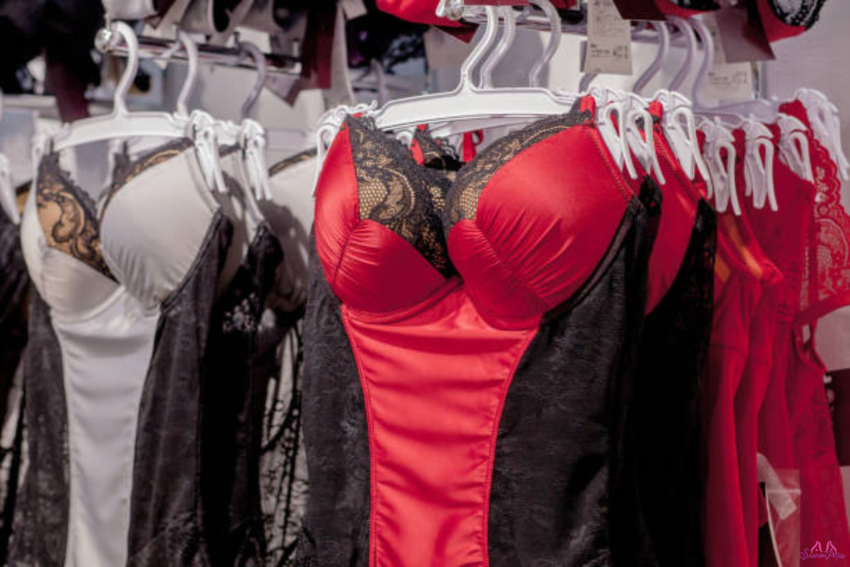 A row of colorful lingerie displayed neatly on hangers in a retail store.